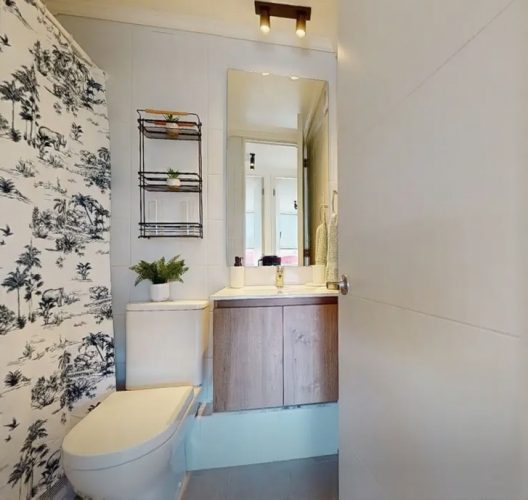 Baño con gran espacio con mueble color café.